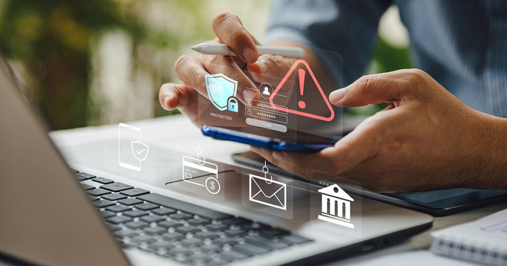 A person using a smartphone and laptop surrounded by digital security and fraud warning icons, illustrating the importance of protecting personal and financial information.