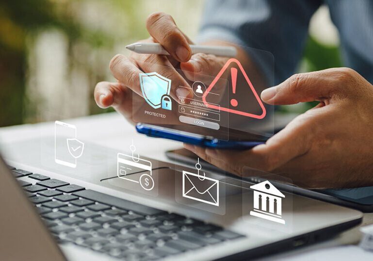 A person using a smartphone and laptop surrounded by digital security and fraud warning icons, illustrating the importance of protecting personal and financial information.