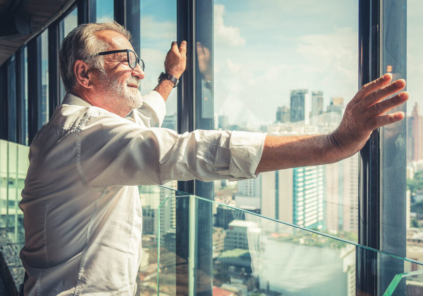 portrait of senior businessman with beard and glasses feeling confident standing in executive room in business building